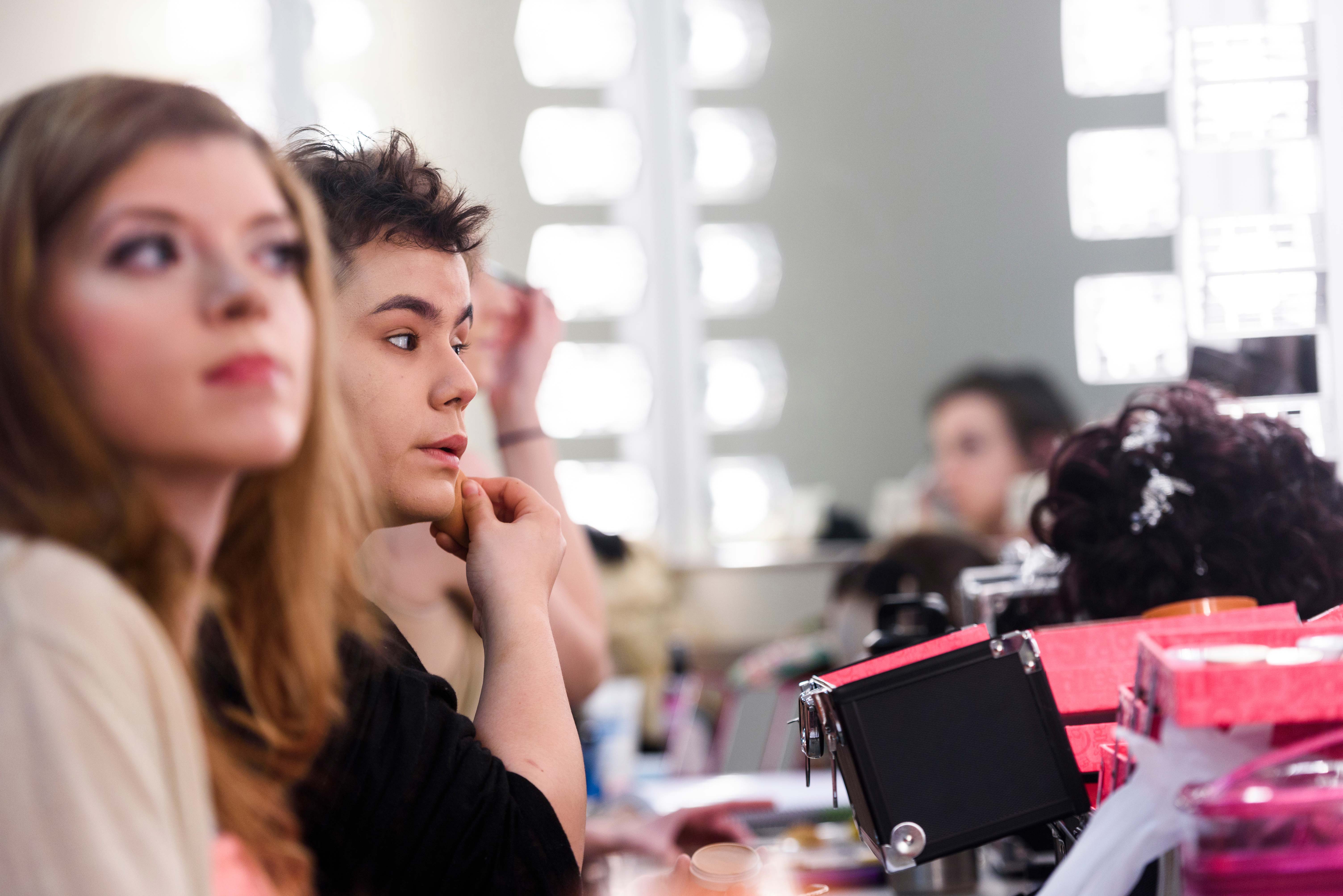 actors applying makeup backstage